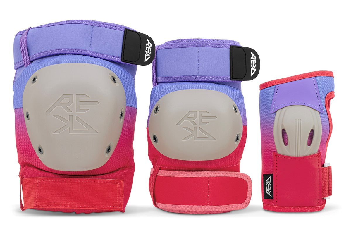 The REKD Shield Triple Skate Protection Pad Set in Fade Red/Violet includes three upright protective pads—a knee pad, an elbow pad, and a wrist guard—each designed by REKD for action sports protection and displayed against a white background.