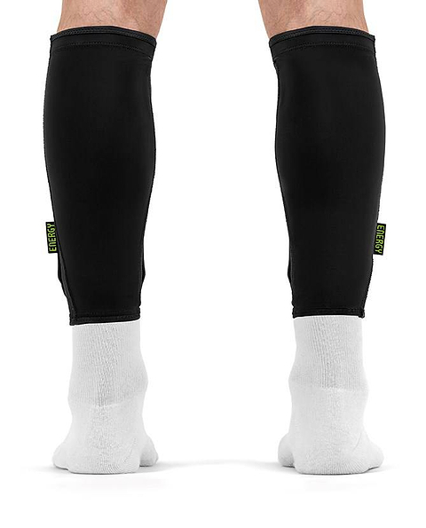 Black slim REKD Energy Covert Long Shin Skate Protection Guards worn over white socks on a person’s lower legs for protection.