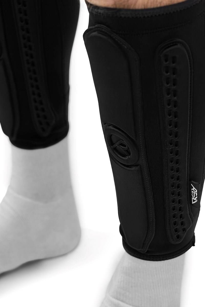 Black REKD Energy Covert Long Shin Skate Protection Guards worn over white socks.