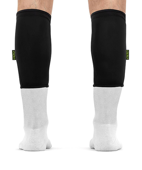 Black REKD Energy Covert Short Shin Skate Protection Guards worn for impact protection over white socks on a person’s lower legs.
