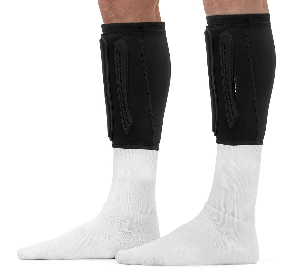 REKD Energy Covert Short Shin Skate Protection Guards in black worn over white socks on a person’s lower legs, providing slim impact protection.