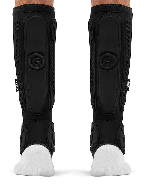 Pair of black REKD Energy Covert Long Shin and Ankle Skate Protection Guards worn over white socks.