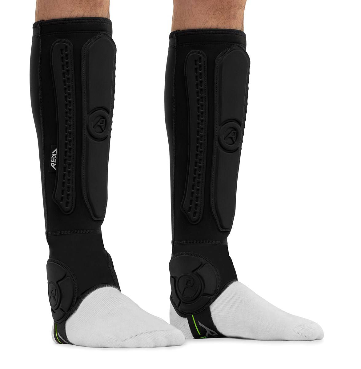 Black REKD Energy Covert Long Shin and Ankle Skate Protection Guards worn on the lower legs over white socks, providing essential BMX ankle protection.