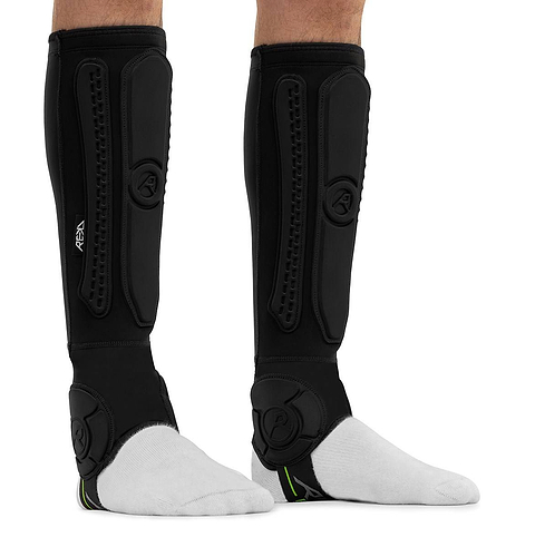 Black REKD Energy Covert Long Shin and Ankle Skate Protection Guards worn on the lower legs over white socks, providing essential BMX ankle protection.