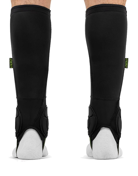 Pair of black REKD Energy Covert Short Shin and Ankle Skate Protection Guards worn on the lower legs, each featuring a small vertical label that reads “ENERGY.”