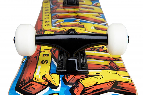 Close-up of the Tony Hawk 540 Series Smash Complete Skateboard’s black trucks and white wheels mounted on a hardrock maple deck featuring bold, colorful, graffiti-style graphics. Deck size: 7.75″ x 31″.