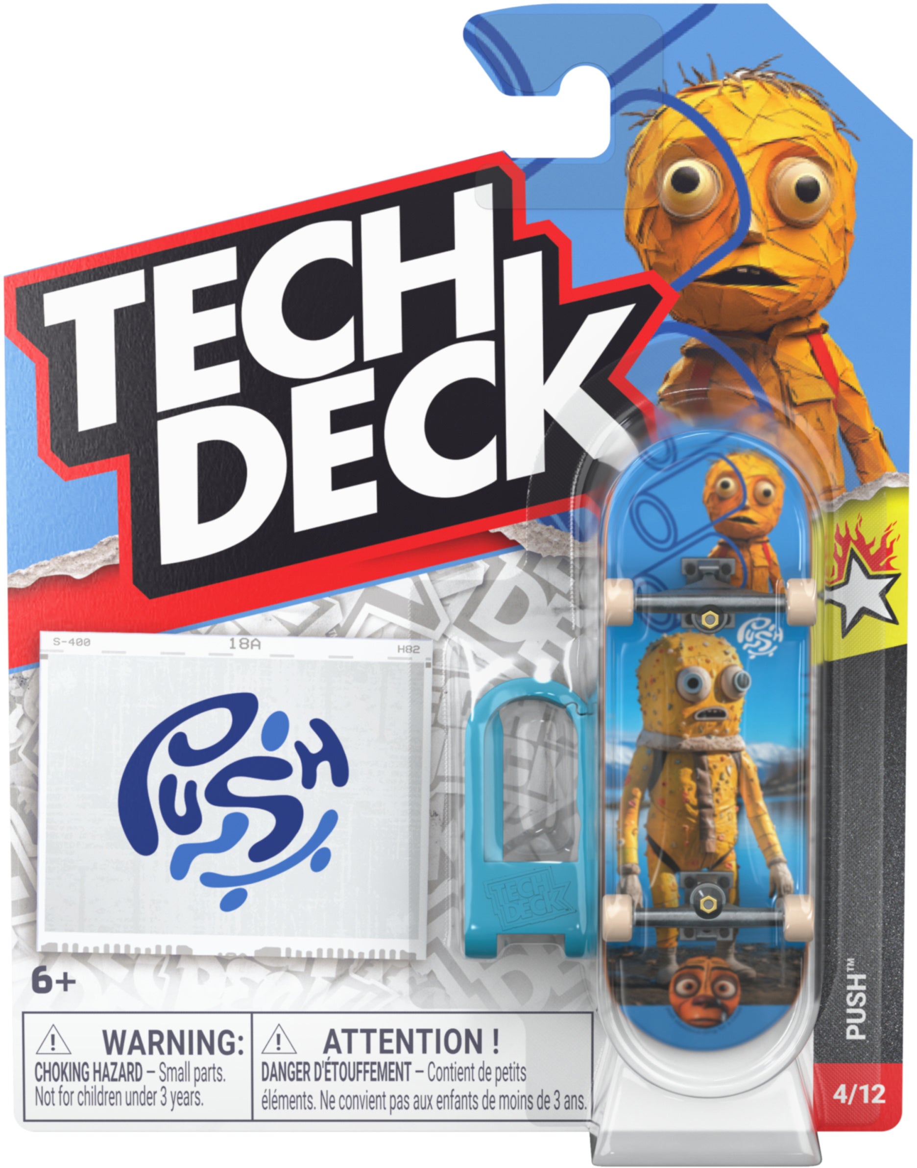 Tech Deck 96mm M61 Fingerboard - Push featuring a cartoon character with large eyes, packaged with a blue plastic barrier and a sticker sheet labeled “PUSH.”