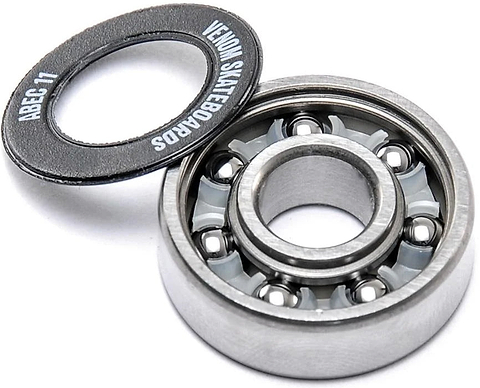 A Venom ABEC 11 Skateboard Bearings - 8 Pack shown with its detached black rubber shield, displaying the brand name and precision rating.