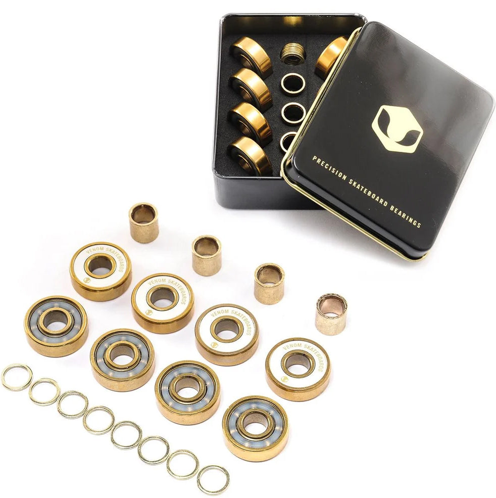Venom Precision Gold Skateboard Bearings - 8 Pack, including eight small metal spacers, eight thin washers, and a black metal storage tin containing additional parts.