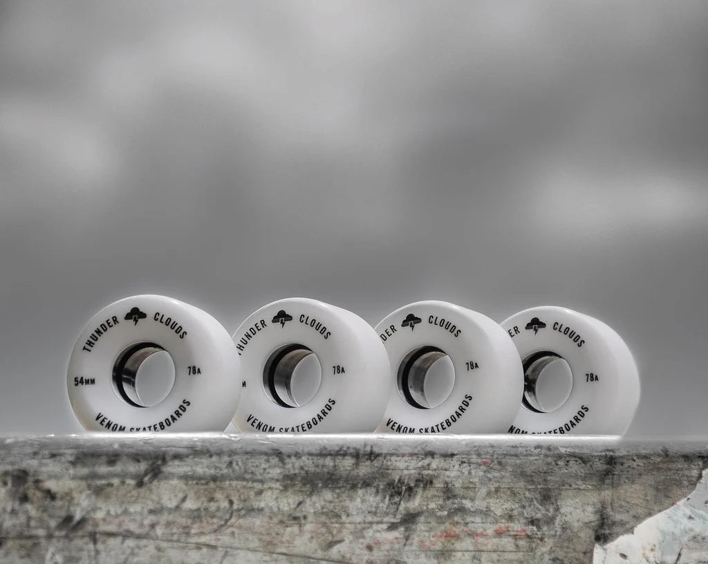 Four white Venom Thunder Clouds V2 52mm 78A Skateboard Wheels - White lined up horizontally, each printed with black text.