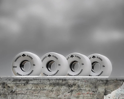 Four white Venom Thunder Clouds V2 52mm 78A Skateboard Wheels - White lined up horizontally, each printed with black text.