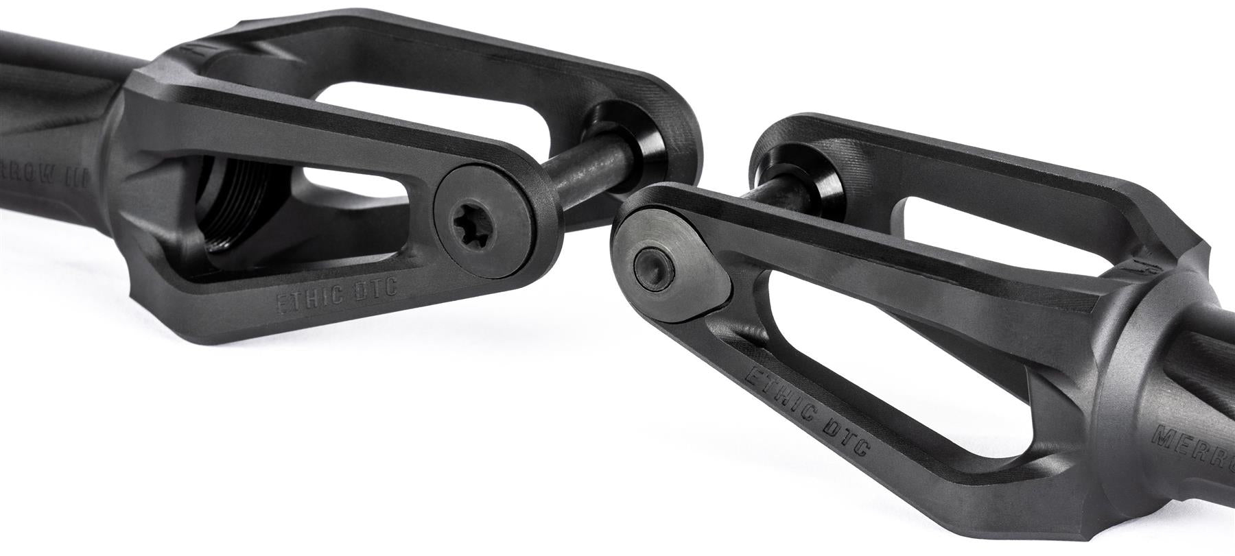 Close-up of two Ethic DTC Merrow V3 8/12STD SCS Stunt Scooter Forks in black, featuring open triangular designs and central bolts, positioned facing each other against a white background.