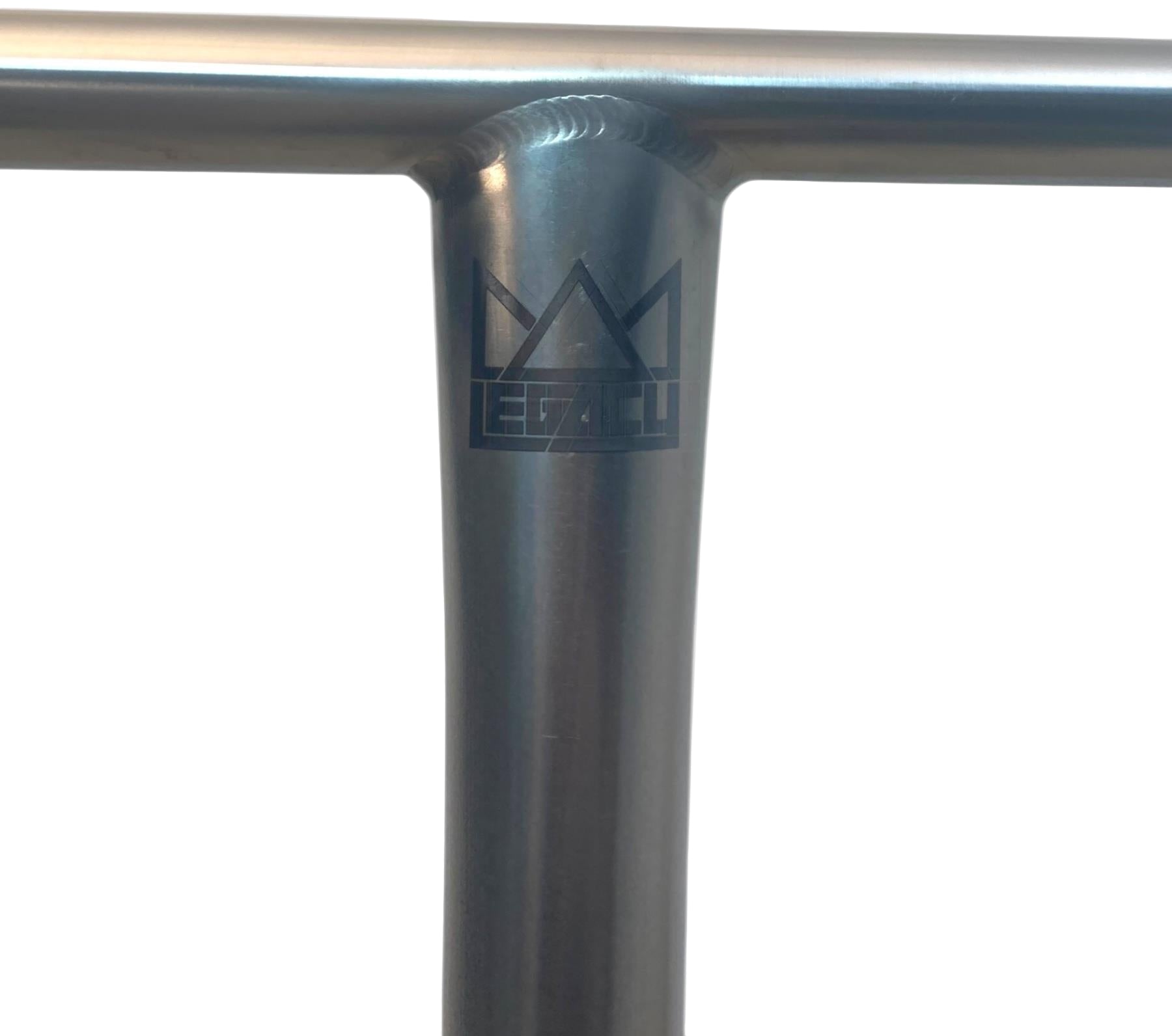 Close-up of the Legacy Titanium Oversized HIC Stunt Scooter T-Bars (Chrome, 690mm x 610mm) with a laser-etched crown and "Elyts" logo on the joint where the vertical and horizontal bars meet.
