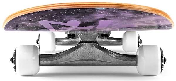 The Enuff Skully Hologram Black Complete Skateboard (7.75" x 31.5") features metallic trucks and light-colored wheels set against a cosmic-themed, 7-ply maple deck with a skeleton silhouette, making it an excellent entry-level board.