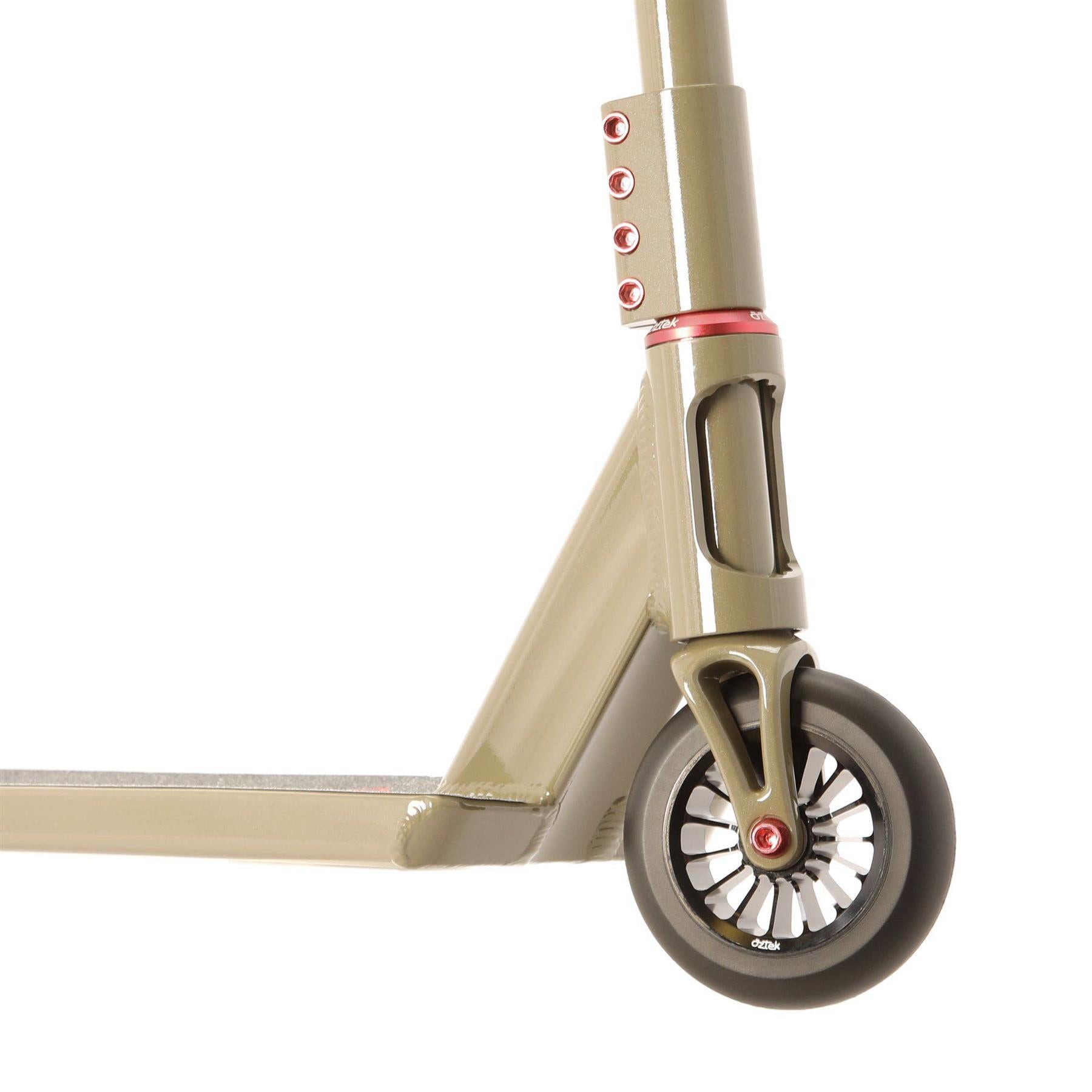 Close-up of the front wheel and lower frame of the Aztek Siren Complete Street Stunt Scooter in Zircon Sand, featuring red accents and a spoked black and white wheel.