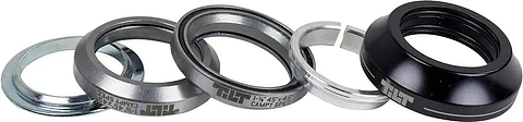 Five components of the Tilt Tall Stack Integrated Stunt Scooter Headset by Tilt—including two silver bearing cups with sealed bearings, a silver washer, a thin silver ring, and a black top cap—are displayed in a row on a white background.