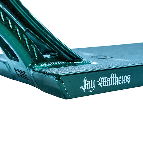 Close-up of the CORE ST3 Forged Green J.Matthews Signature Street Stunt Scooter Deck (6.5" x 22.5") by CORE, showing "Jay Matthews" in white gothic lettering on the side, with angular lines and reinforced welds.