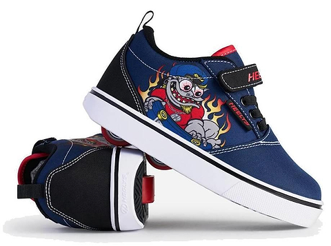 A pair of Heelys Pro 20 Prints X2 Boys Shoes in navy and red by Heelys, with white soles; one upright, one on its side displaying the wheel. Features a cartoon monster skateboarding with flames in the background.