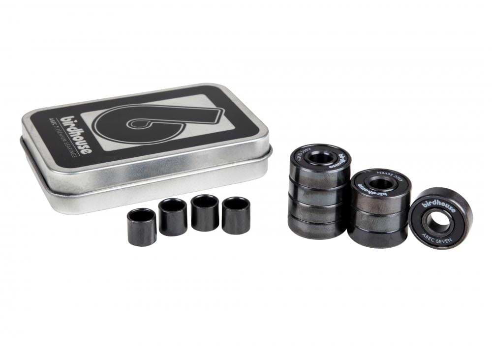 A tin box marked with "Birdhouse" sits adjacent to both stacked and separate premium skateboard bearings and spacers. The ABEC 7 bearings prominently feature the label "Birdhouse ABEC Seven." The image, set against a pristine white background, accentuates the quality of the Birdhouse ABEC 7 Black Skateboard Bearings - 8 Pack.