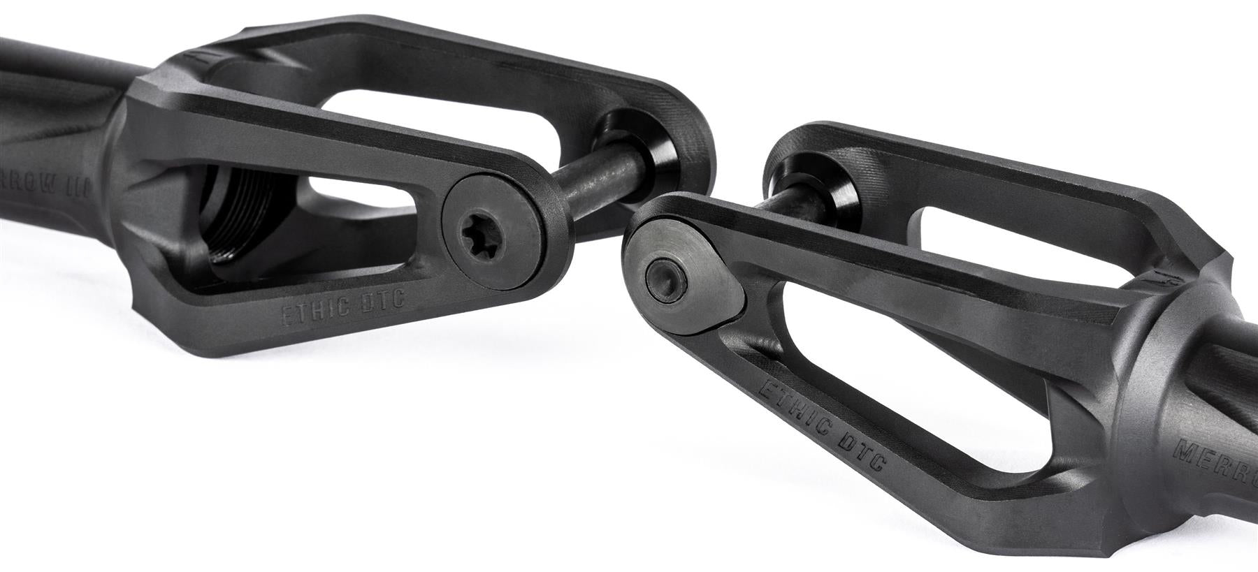Two black Ethic DTC Merrow V3 8/12STD IHC stunt scooter forks with angular, open-frame designs are positioned facing each other. Each lightweight fork features a central bolt and has "Ethic DTC" branding on the surface.