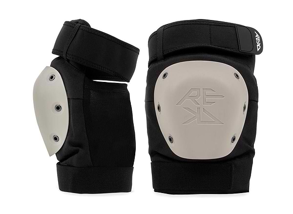 A REKD Shield Triple Skate Protection Pad Set in black and beige, featuring reinforced hard shells, adjustable straps, and "REKD" branding. Designed by REKD for reliable action sport protection during intense activities.