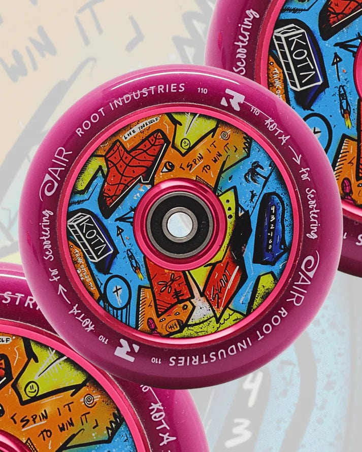 The Root Industries x KOTA Limited Edition AIR 110mm Stunt Scooter Wheel in purple features a graffiti-inspired design with abstract shapes, arrows, text, and the words "ROOT INDUSTRIES AIR" and "for scootering" around the rim.