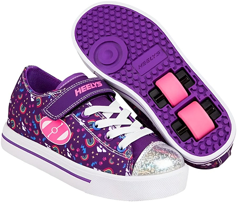 A pair of Heelys Snazzy X2 Girls Shoes by Heelys in purple, multi, and rainbow colors, featuring star patterns, white laces, a sparkling silver toe cap, and pink double wheels visible in the sole of one shoe.