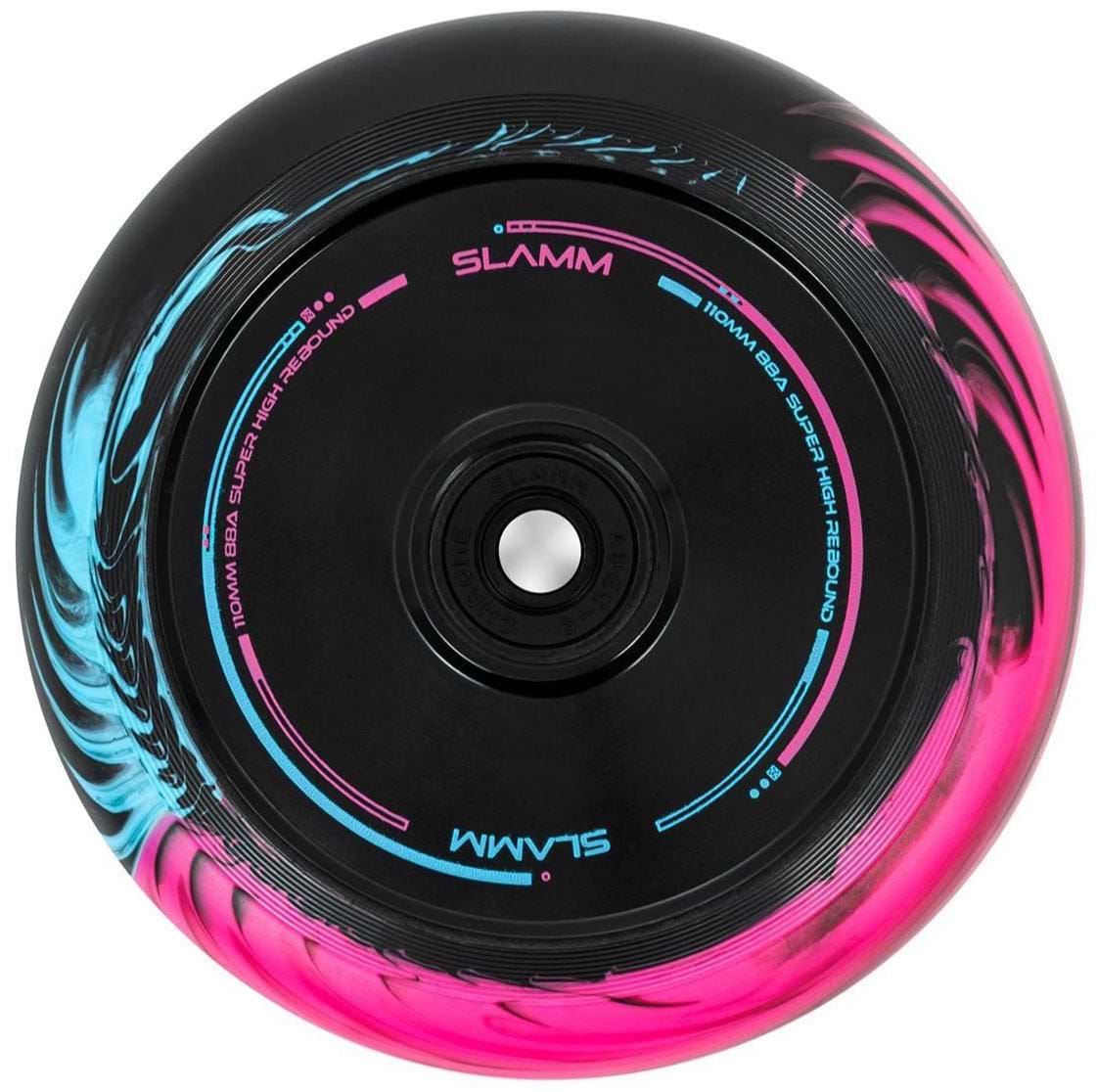 The Slamm Swirl 110mm Stunt Scooter Wheel, in an eye-catching black, blue, and pink color combination, features a vibrant duo-tone swirl effect. The brand "Slamm" is prominently displayed on the wheel, which also includes high-performance ABEC-9 chrome bearings for a smooth ride.