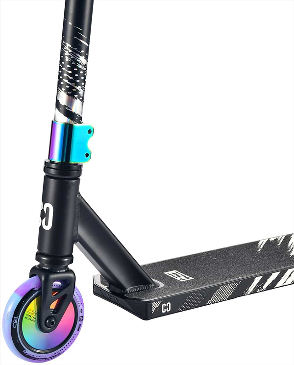 Close-up of the CORE CB1 Beginner Complete Stunt Scooter by CORE in Black/Neochrome, highlighting the front rainbow neochrome wheel, black deck with white graphics, and a blue-green metallic clamp.