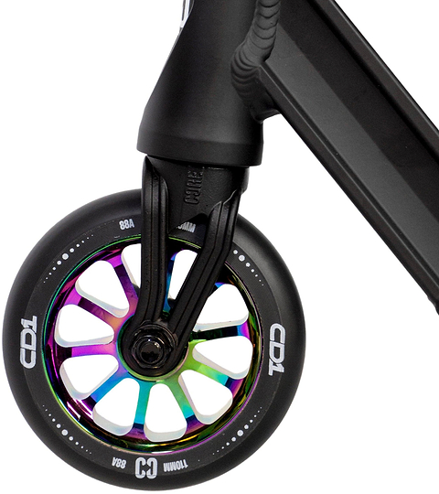 Close-up of a CORE CD1 Complete Stunt Scooter (Neochrome/Black) front wheel by CORE, featuring a metallic rainbow core, black tire, bold white lettering, and attached to a sleek black fork and deck.