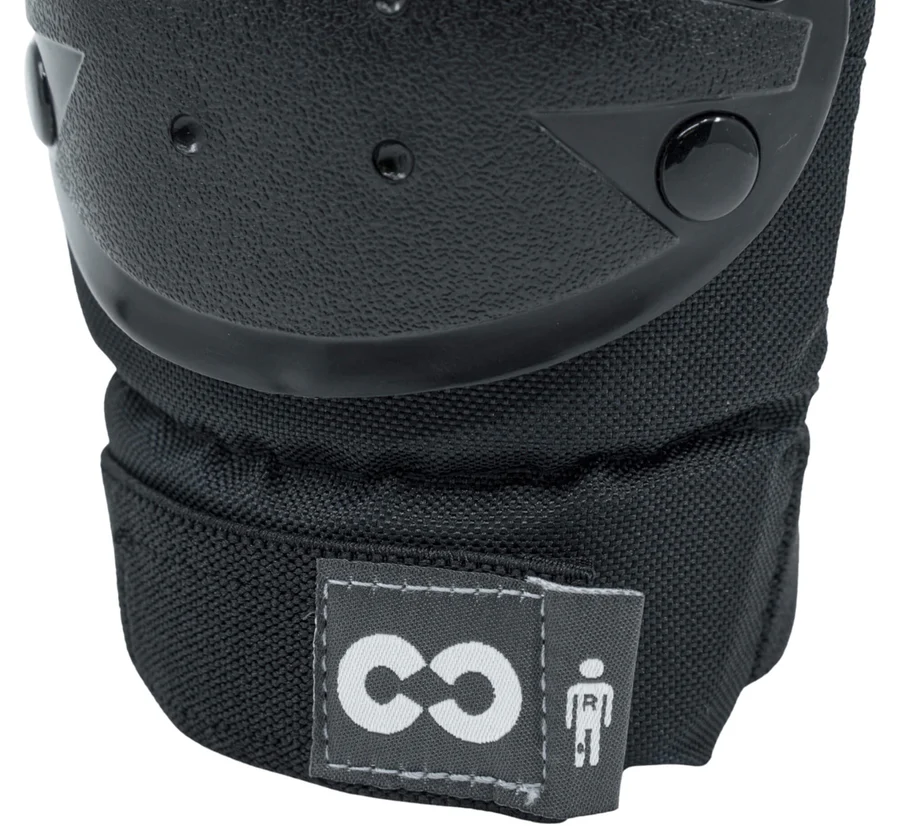 Close-up of a CORE Junior Triple Skate Protection Pad Set in black/grey, featuring a hard plastic shell and stitched fabric base. A small tag with CORE's white logo emphasizes skatepark safety for kids.