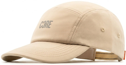 The CORE Performance Cap by CORE features “CORE” in reflective gray lettering on the front, crafted from breathable fabric in a sand color with detailed stitching and an adjustable strap at the back.