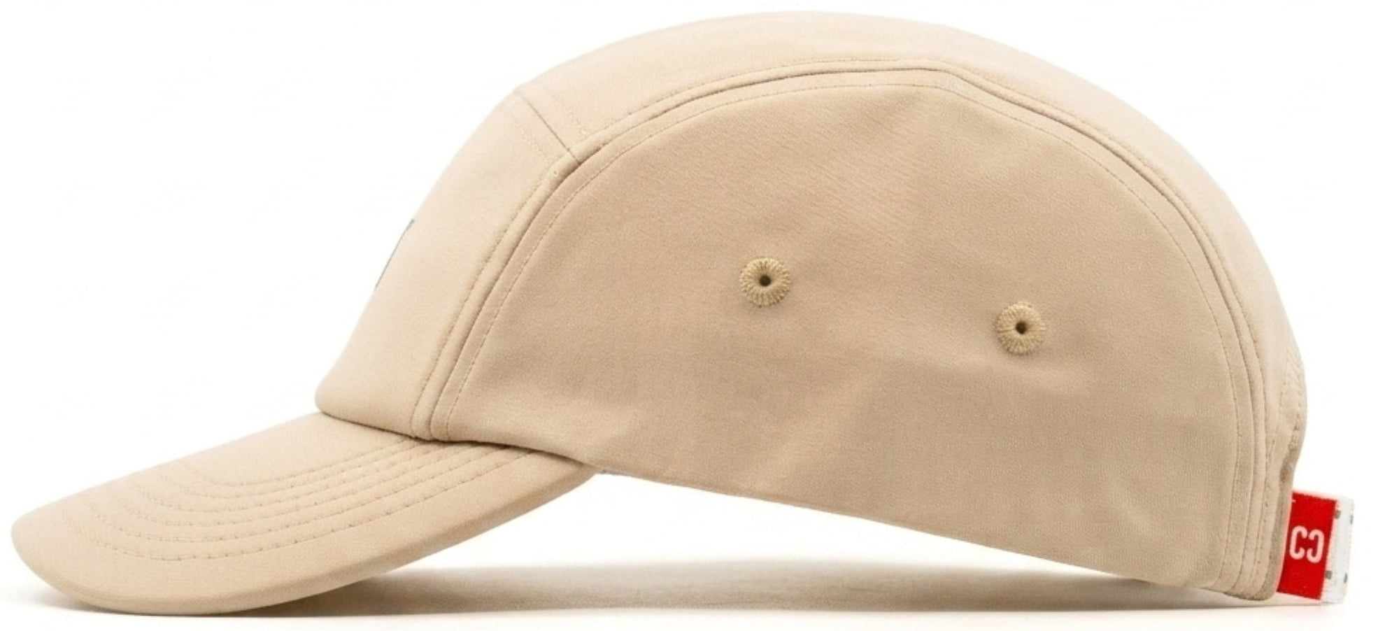 The CORE Performance Cap in Sand / Reflective is displayed in a side profile against a white background. Crafted from breathable fabric, this beige cap by CORE features two small ventilation holes on the side and is finished with a red tag with white text near the back.