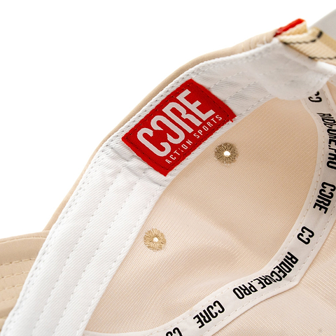 Close-up of the inside of the CORE Performance Cap - Sand / Reflective, featuring a red “CORE ACTION SPORTS” label and black “CORE PRO” text on the inner band. The breathable fabric by CORE ensures comfort during active use.