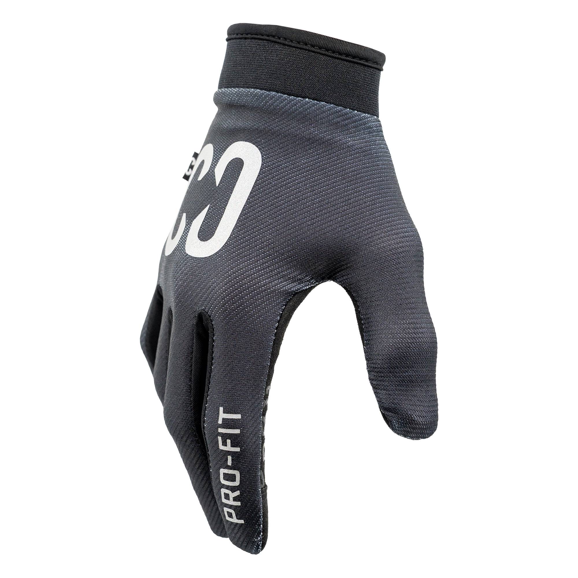 A pair of CORE Pro-Fit Velcro Skate Protection Gloves in reflective black, featuring “PRO-FIT” on the index finger and white “CO” branding on the back, shown worn on a hand against a white background—ideal as BMX or riding gloves.