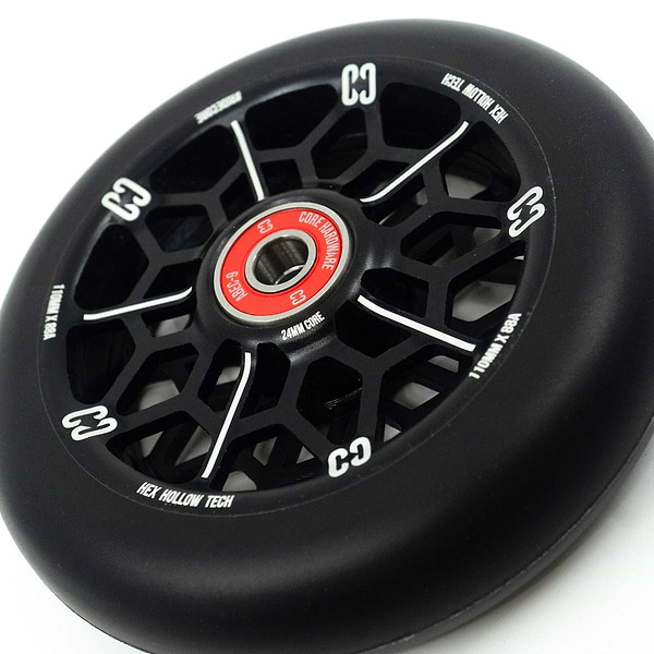 A detailed view of the CORE Hex Hollow Core 110mm Stunt Scooter Wheel in black showcases its striking red core and HEX Hollow Tech design. The distinctive spoke pattern pairs seamlessly with CORE's logo and markings present on both the wheel and core. Outfitted with ABEC 9 bearings, this hollow core stunt scooter wheel delivers exceptional performance.