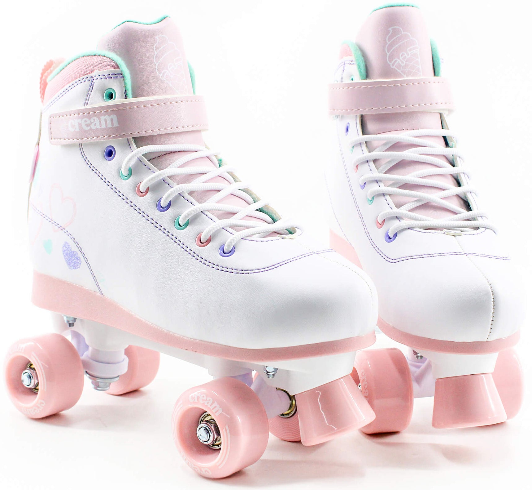 The CREAM Scoop Hearts Adjustable Quad Roller Skates in white and pink feature vegan leather construction, heart and ice cream designs, pink wheels, and pastel accents on the eyelets and soles—making them the perfect beginner skates for those seeking both style and comfort.
