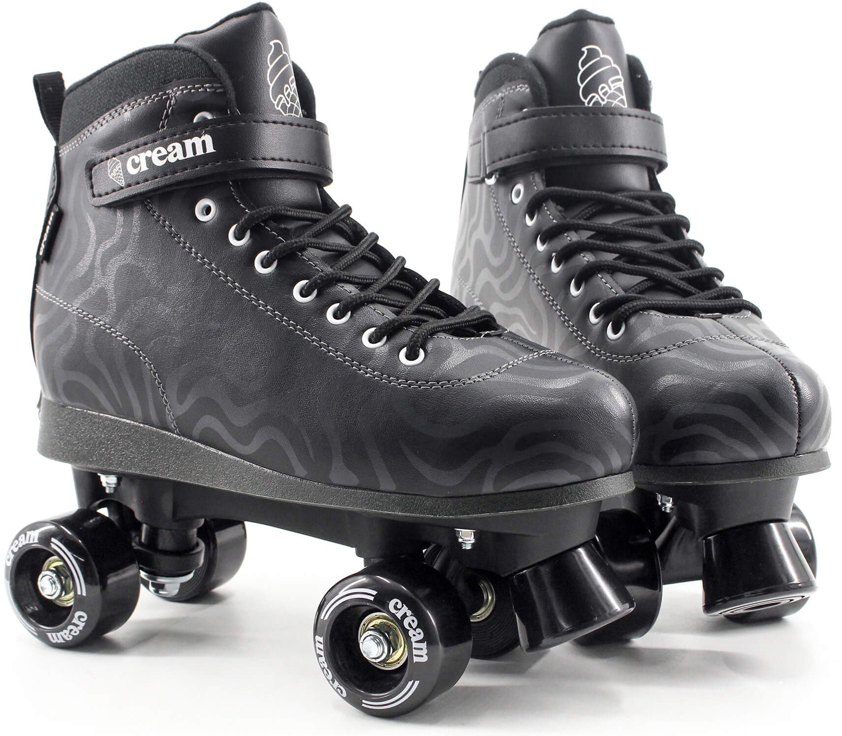 A pair of CREAM Scoop Wave Adjustable Quad Roller Skates in black, crafted from vegan leather and featuring laces, ankle straps, and four wheels each. These adjustable quad skates showcase subtle wavy patterns along with “CREAM” branding on the strap and wheels.