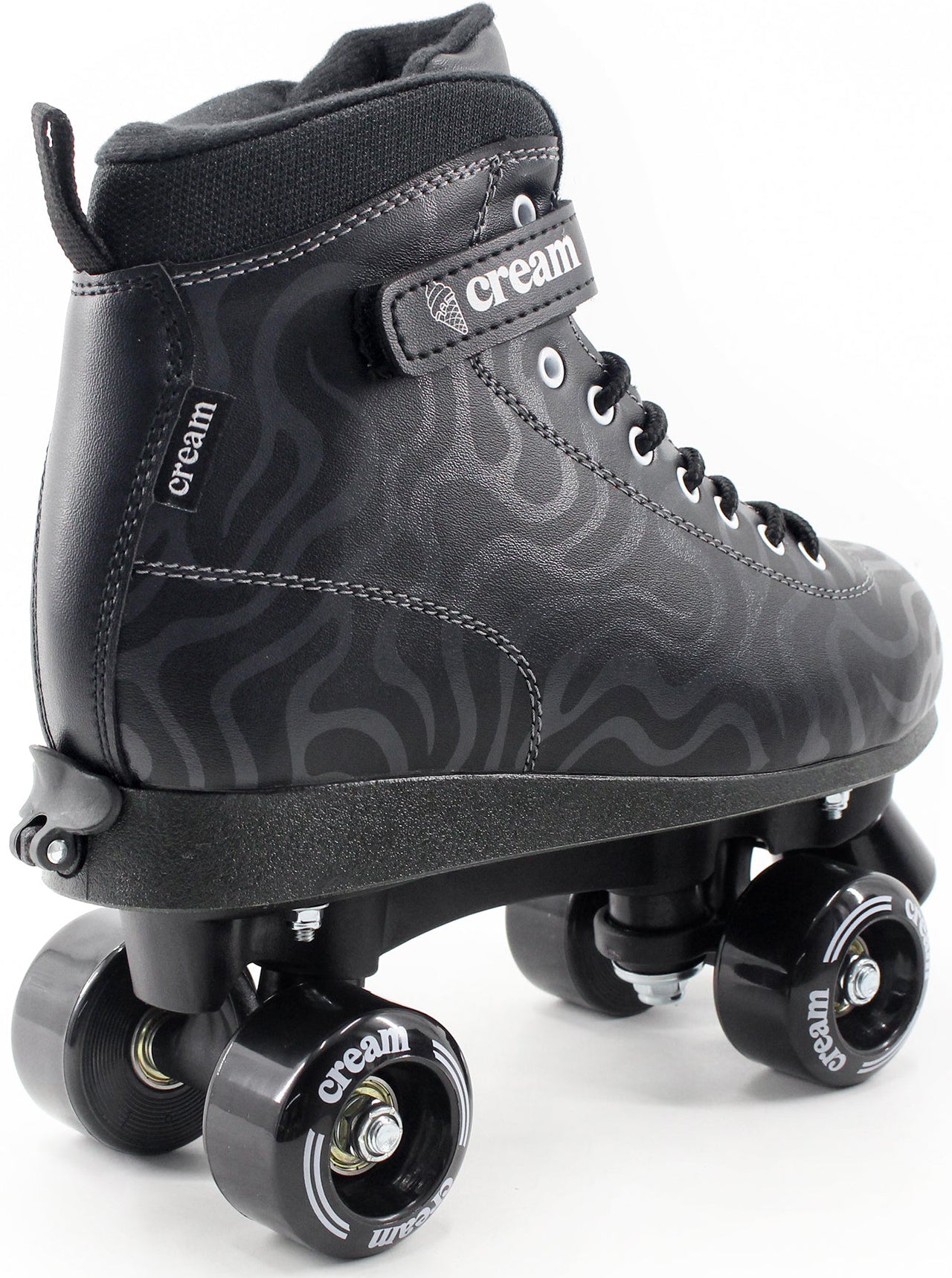 The CREAM Scoop Wave Adjustable Quad Roller Skates in Black feature a swirling pattern and are crafted from vegan leather, with "CREAM" branding on the strap and wheels. Displayed against a white background, these adjustable quad roller skates by CREAM are ideal for beginner skaters seeking both style and comfort.