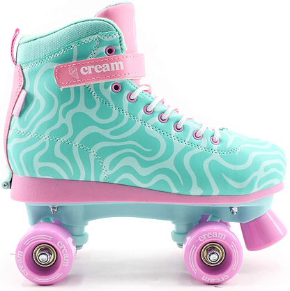 The CREAM Scoop Wave Adjustable Quad Roller Skates in Teal/Pink feature wavy white lines, pink laces, pink wheels, and a matching pink strap—all accented with the word "CREAM" printed on both the strap and wheels. Designed for beginners, these skates from CREAM offer a retro-inspired, playful look that’s sure to stand out.