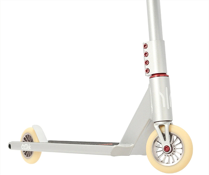 Close-up of the Aztek Architect 2 Complete Stunt Scooter in Platinum Silver, featuring cream wheels, a black deck, red bolts, SCS compression system, and "Aztek" branding on the rear wheel guard.