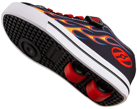 A close-up of the Heelys Snazzy X2 Boys Shoes in Black/Yellow/Red Flame shows red wheels with ABEC 3 bearings, black grip, a flame design on the side, and the "Heelys" logo near the wheels.