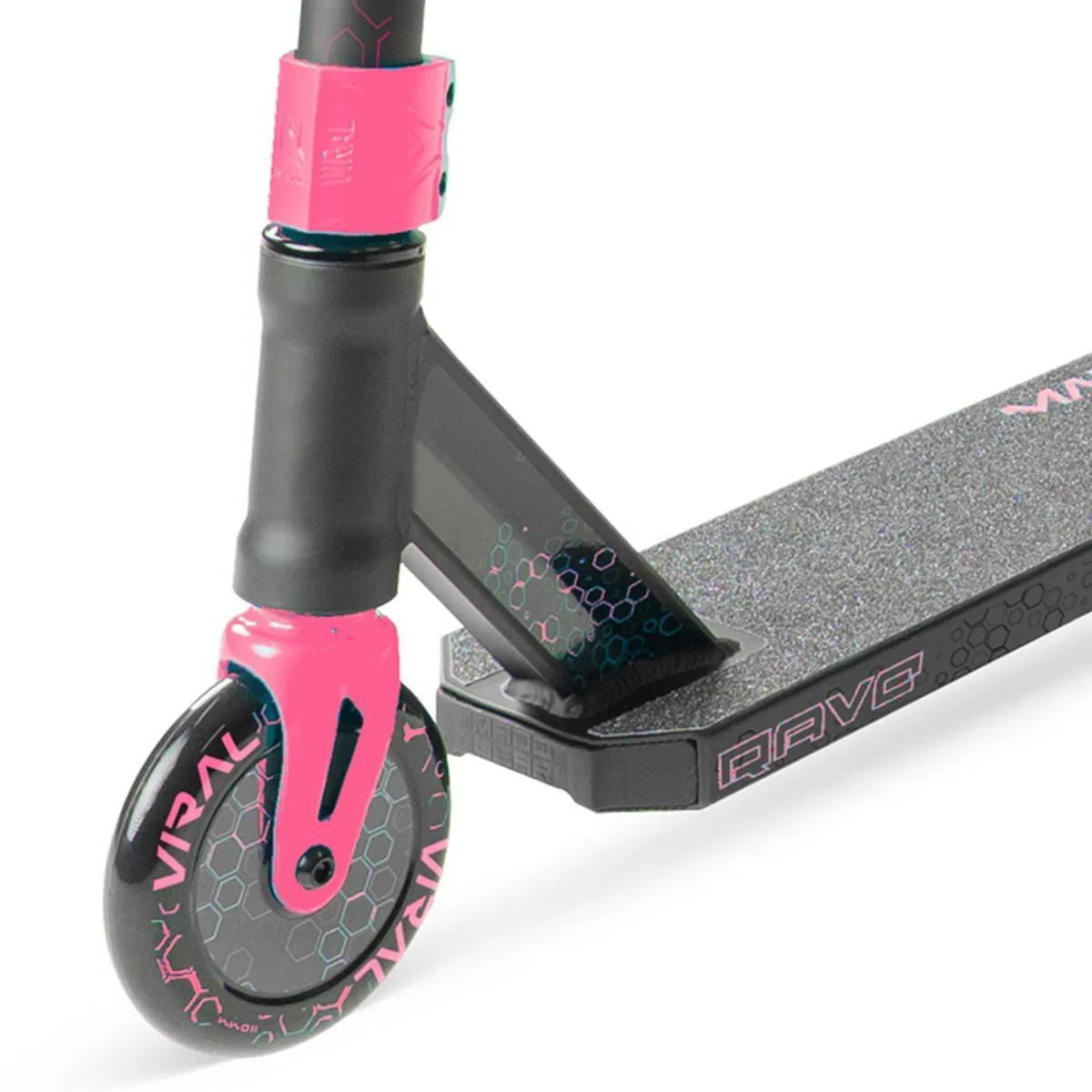Close-up of the Madd Gear Viral Rave Complete Stunt Scooter - Melon, showing the front wheel with "VIRAL," deck, and handlebar stem featuring hexagon patterns. Brand: Madd Gear (MGP).