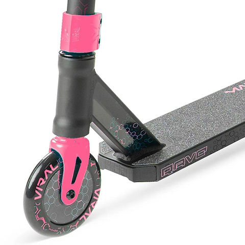 Close-up of the Madd Gear Viral Rave Complete Stunt Scooter - Melon, showing the front wheel with "VIRAL," deck, and handlebar stem featuring hexagon patterns. Brand: Madd Gear (MGP).