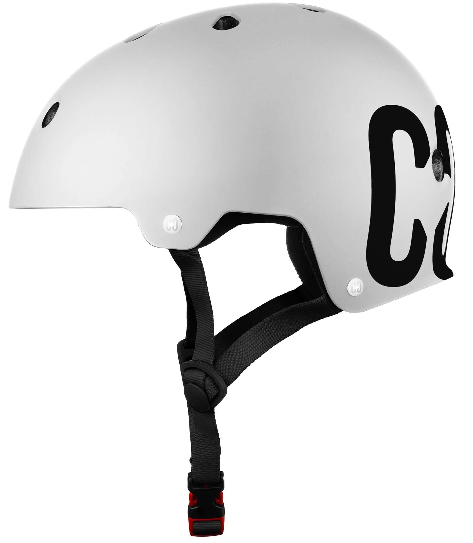 The CORE Street Skate / Scooter Helmet - White by CORE features multiple ventilation holes, black adjustable straps, a red buckle, and large black lettering partially visible on the side.
