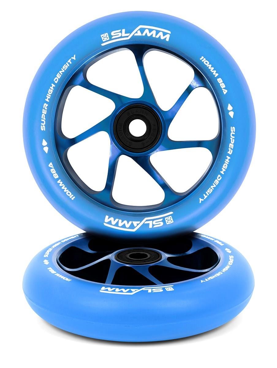 Two Slamm Team 110mm stunt scooter wheels in blue with high-density PU, tough aluminium cores, and "Super High Density" text. One wheel stands upright, the other lies flat. Black spokes and white branding complete the design.