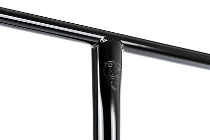 Close-up of Ethic DTC Tenacity V2 Steel Oversized HIC Stunt Scooter T-Bars—Black Mirror, 620mm x 600mm—showing the lightweight T-shaped handlebar with a small embossed shield-shaped "TENACI" logo at the joint.
