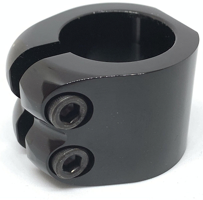 An up-close photograph showcases the Dare Warlord 2 Bolt Standard Stunt Scooter Clamp in black, made by Dare, featuring two hexagonal socket screws and a circular opening with CNC machined precision. This lightweight clamp is perfect for securely fastening or connecting parts in stunt scooter or industrial uses.