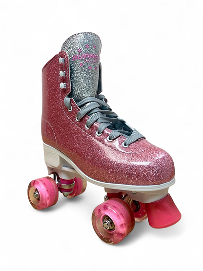 The Supreme Del Rey Adjustable Quad Roller Skates - Pink by Supreme feature glittery pink uppers, pink wheels, gray laces, a white sole, and a silver tongue, shown against a white background.