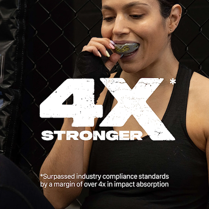 A woman in athletic wear prepares to use the Safejawz Nitro Series Protection Mouthguard - Grey / Yellow. Large text reads "4X STRONGER." Smaller text notes it surpassed industry compliance by over 4x in impact absorption. Brand: Safejawz.